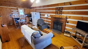 A cozy cabin interior with a living room, dining area, and kitchen.