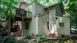 A two-story house with a covered porch and a small deck.