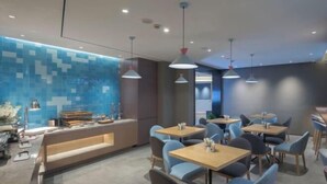 A modern restaurant with blue-tiled walls, pendant lighting, and a variety of seating options including tables and chairs. - Homeinn · neo (Zhaoqing Qixingyan Paifang) (Zhaoqing)