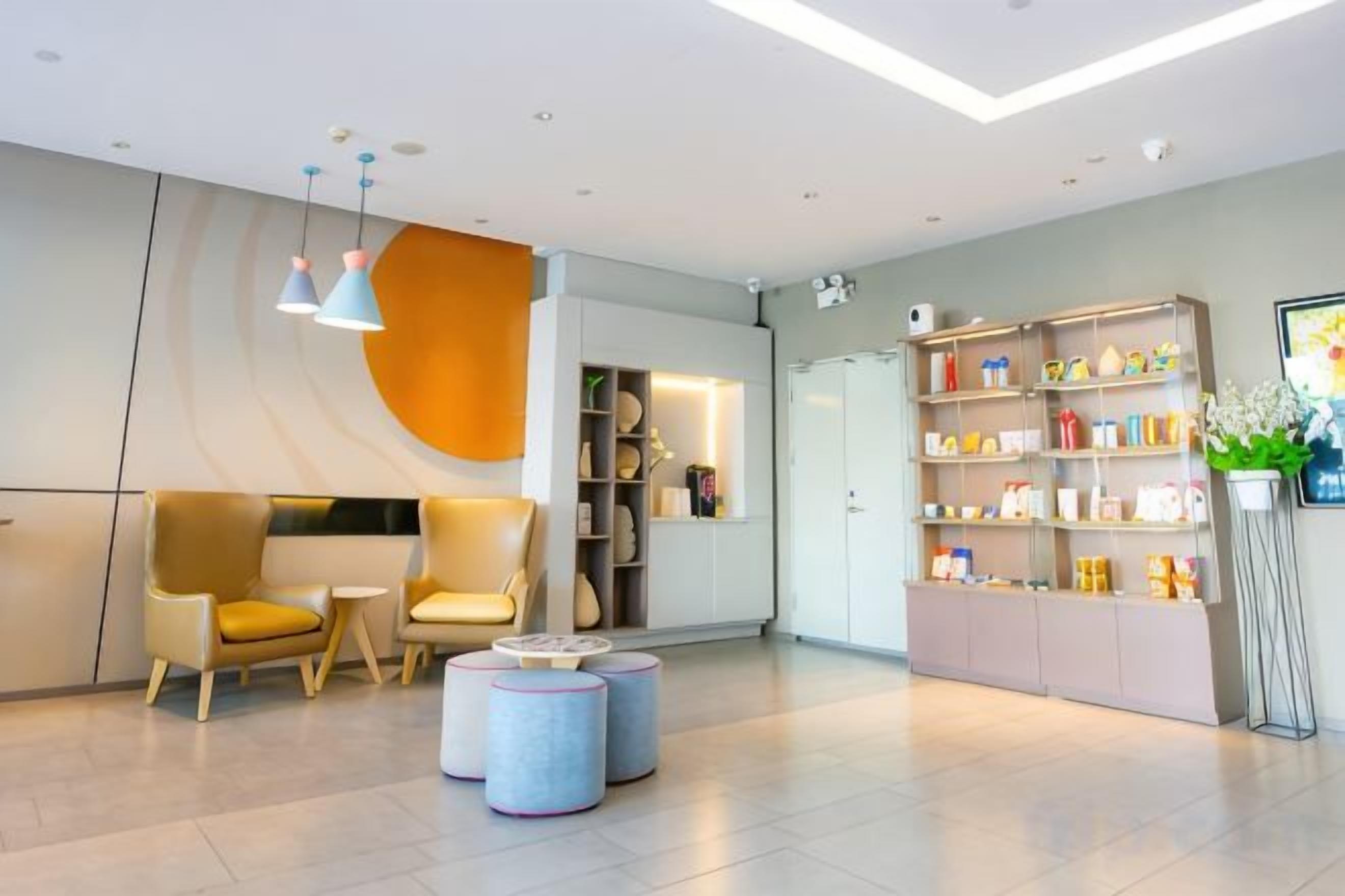 A modern reception area with a sofa, chairs, a bookshelf, and a small table.
