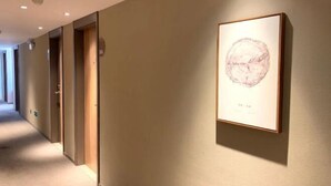 A hallway with doors and a framed artwork on the wall. - Homeinn · neo (Zhaoqing Qixingyan Paifang) (Zhaoqing)
