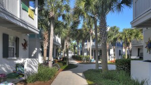 A residential street lined with palm trees and houses with balconies. - 🏖30A Bridge to Paradise Bungalow 146: 2Bed/2Bath, 400 yds to Beach🏖 (Santa Rosa Beach)
