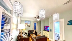 A living room with a sofa, a coffee table, a TV, and decorative lighting. - 🏖30A Bridge to Paradise Bungalow 146: 2Bed/2Bath, 400 yds to Beach🏖 (Santa Rosa Beach)
