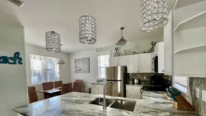 A modern kitchen with a marble countertop, stainless steel appliances, and pendant lighting. - 🏖30A Bridge to Paradise Bungalow 146: 2Bed/2Bath, 400 yds to Beach🏖 (Santa Rosa Beach)