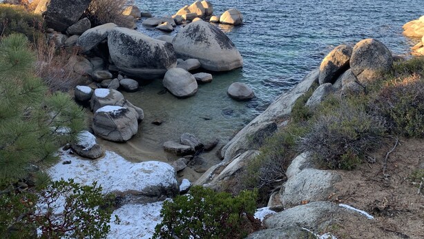 A rocky shoreline with large boulders and sparse vegetation. - Peaceful Creekside Retreat with Pool Access, Family-Friendly (Incline Village)