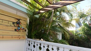 Una pared de madera con un tapiz decorativo y una cerca blanca con formas de piña.