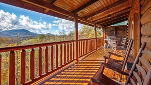 Ein Holzboden mit Schachbrettmuster, Holzgeländern und Blick auf Berge.