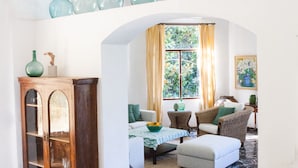 A spacious living area with a high ceiling, a wooden cabinet, a sofa set, and a dining table. - Stunning Villa and Garden w/ Pool and Sweeping Views in the Heart of Fornalutx (Fornalutx)