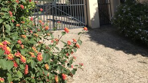 A gated entrance with a gravel path leading to a building with a stone facade. - Stunning Villa and Garden w/ Pool and Sweeping Views in the Heart of Fornalutx (Fornalutx)