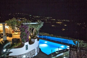 Vue nocturne d’un espace piscine offrant une vue dégagée sur le paysage environnant.