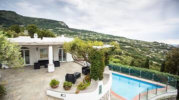 Relax by the pool surrounded by lush greenery and rolling hills.
