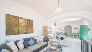 A spacious living room with a sofa, coffee table, and artwork on the wall. - Villa Marina (Praiano)