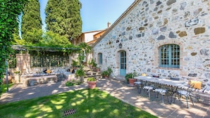 A stone building with a patio area featuring outdoor seating and a table. - Antico Brunello (Montalcino)