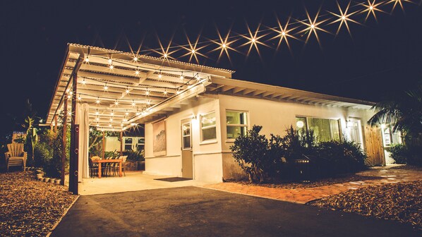 Una casa con un patio techado, comedor y entrada bien iluminada.