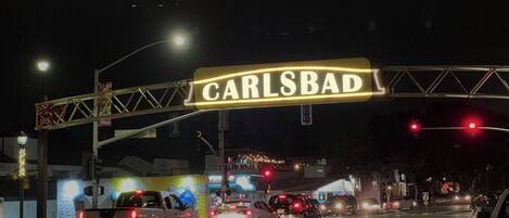 A street sign with the name 'CARLSBAD' at night.