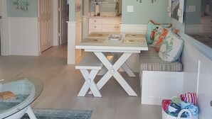 A spacious living area with a dining table, a comfortable seating area, a kitchen in the background, and a ceiling fan. - CONDO BY THE BEACH #2 (Naples)