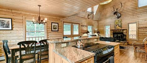 Een houten cabin met keuken, eethoek en open haard.
