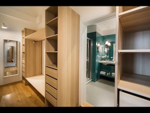 Ein modernes Interieur mit Holzbögen, einem begehbaren Kleiderschrank und einem Badezimmer mit Türkis-Akzentwand.