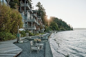 A waterfront property with a wooden deck, outdoor seating, and a sign indicating a spa quiet zone. - The Inn at Langley (Langley)