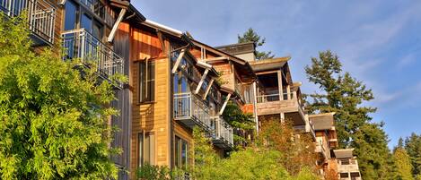 A multi-story building with balconies and a wooden facade.