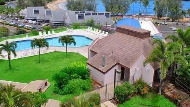 Un resort con una gran piscina, playa y vistas al océano.