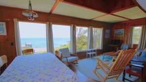 Una habitación acogedora con una cama grande, paredes de madera y vista al océano.