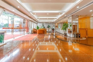 A hotel lobby with a polished floor, seating area, and a reception desk. - May King Grand Hotel (Guangzhou)