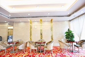 A hotel room with a red carpet, a large mirror, and a plant. - May King Grand Hotel (Guangzhou)