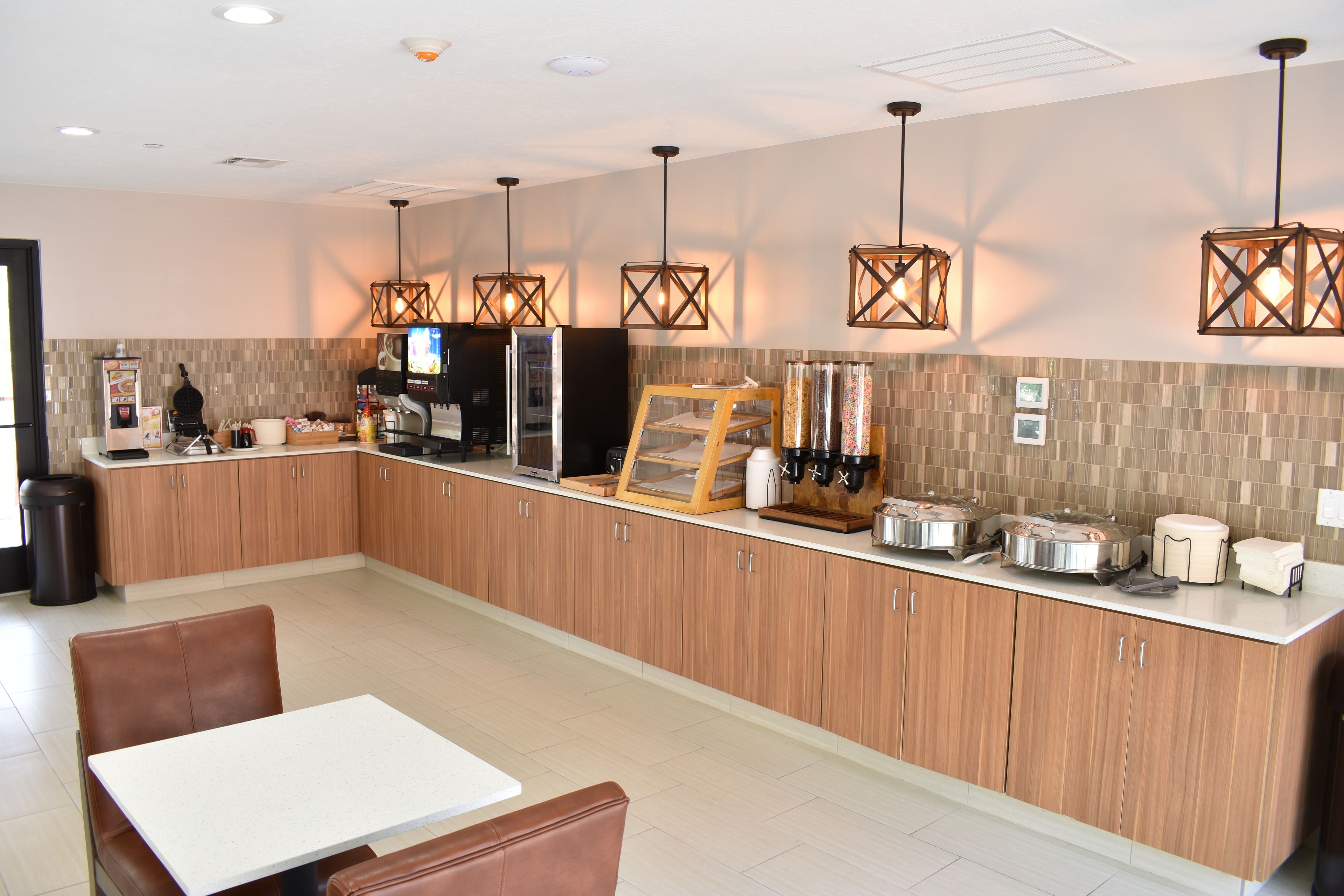 Eine moderne Küche mit Holzausstattung, einer Kaffeestation und Pendelleuchten.