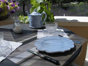 A table set for a meal with a teapot, cup, plate, and cutlery.