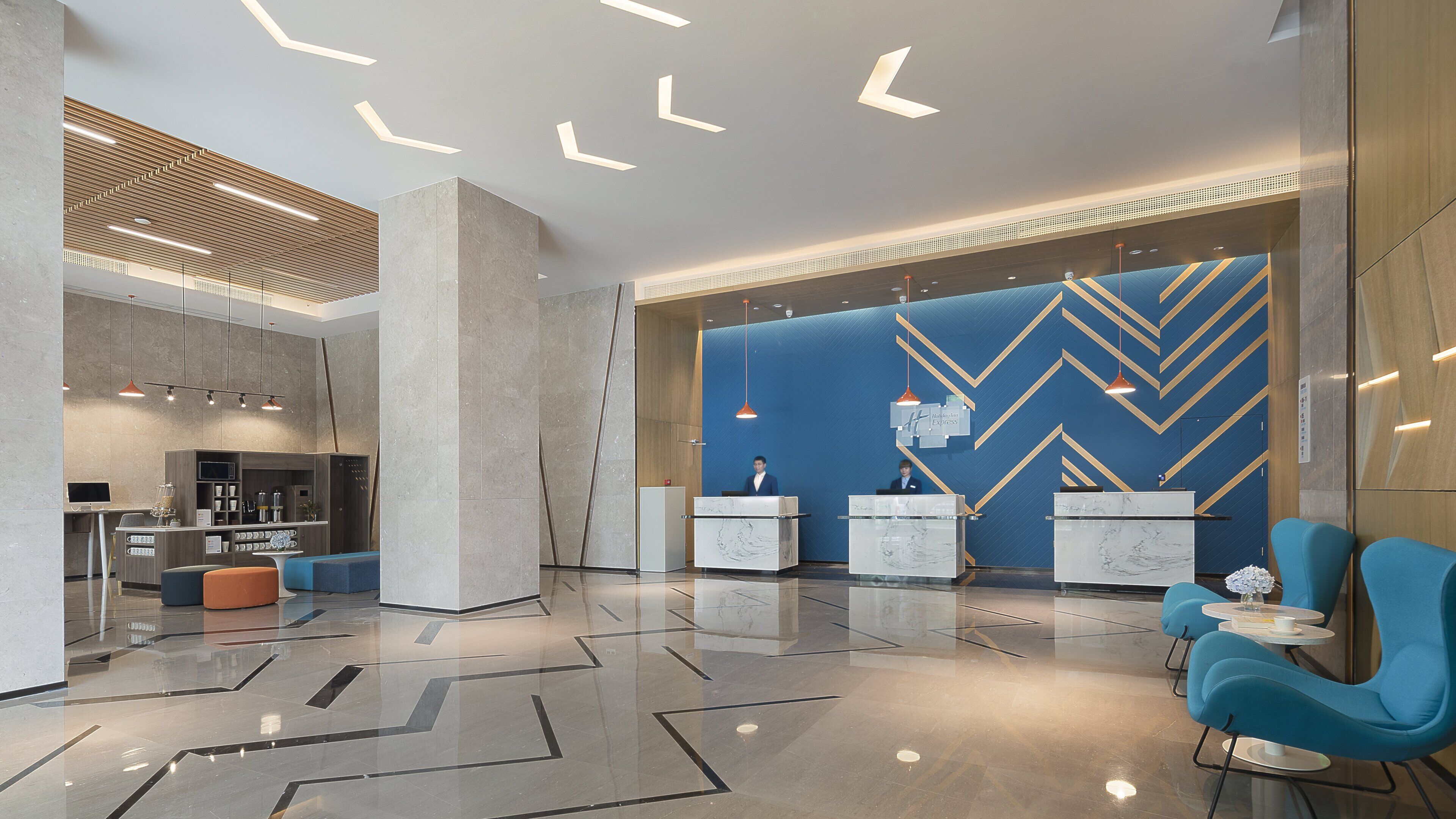 Un moderno vestíbulo de hotel con mostrador de recepción, zona de estar y bar.