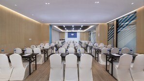 A conference room with rows of white chairs, tables, and water bottles. - Holiday Inn Express Nanjing Dongshan by IHG (Nanjing)