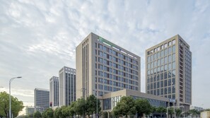 A modern multi-story building with a prominent sign for 'Holiday Inn Express'. - Holiday Inn Express Nanjing Dongshan by IHG (Nanjing)