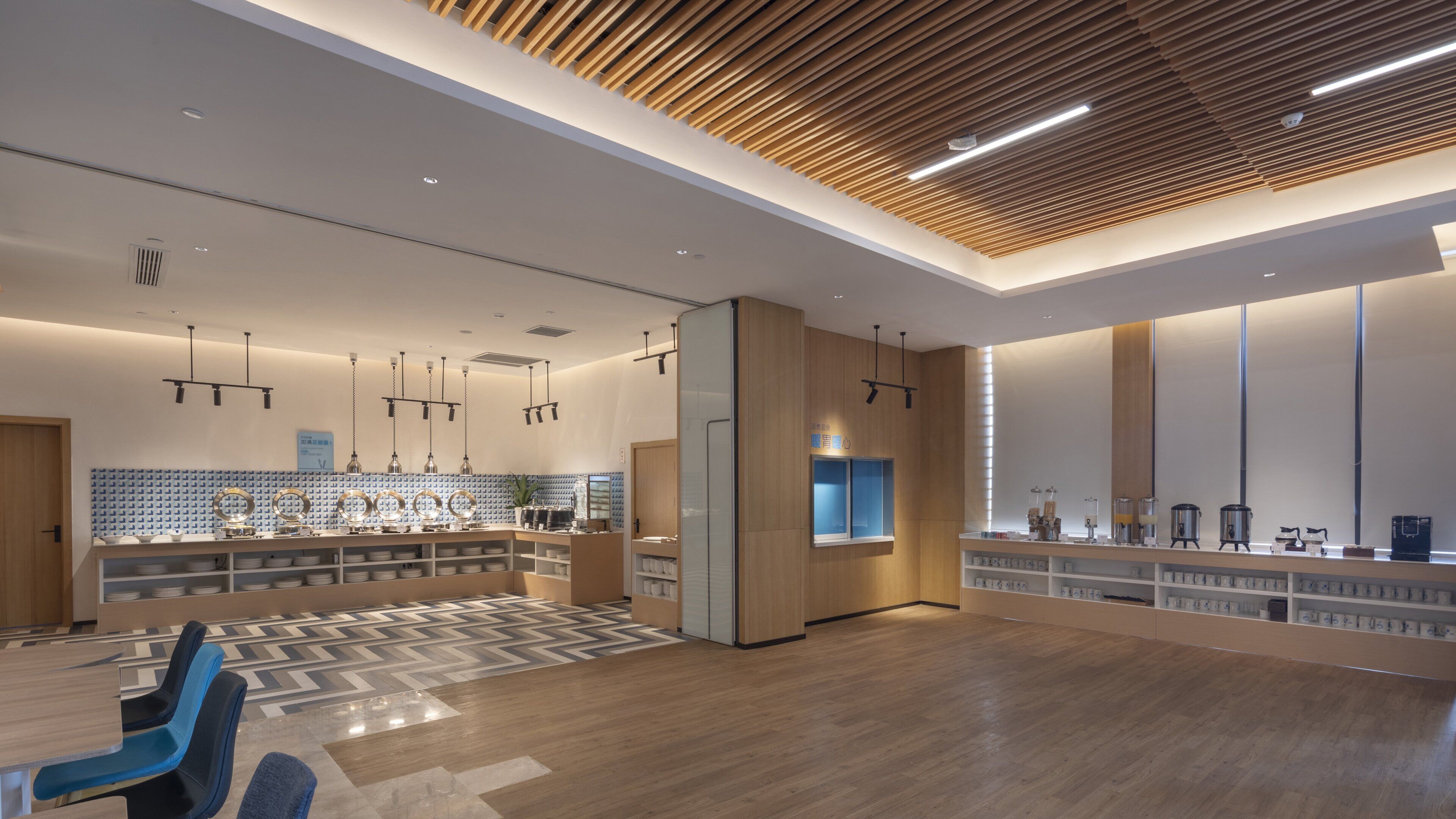 A modern kitchen with a central island, pendant lighting, and a patterned floor.
