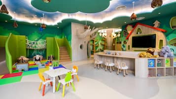 A children's play area with a slide, climbing structures, and a play table.