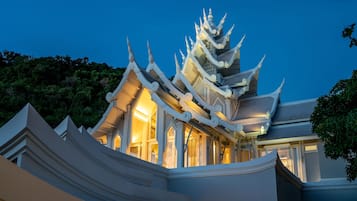 A traditional multi-tiered temple with ornate architecture and illuminated interior.