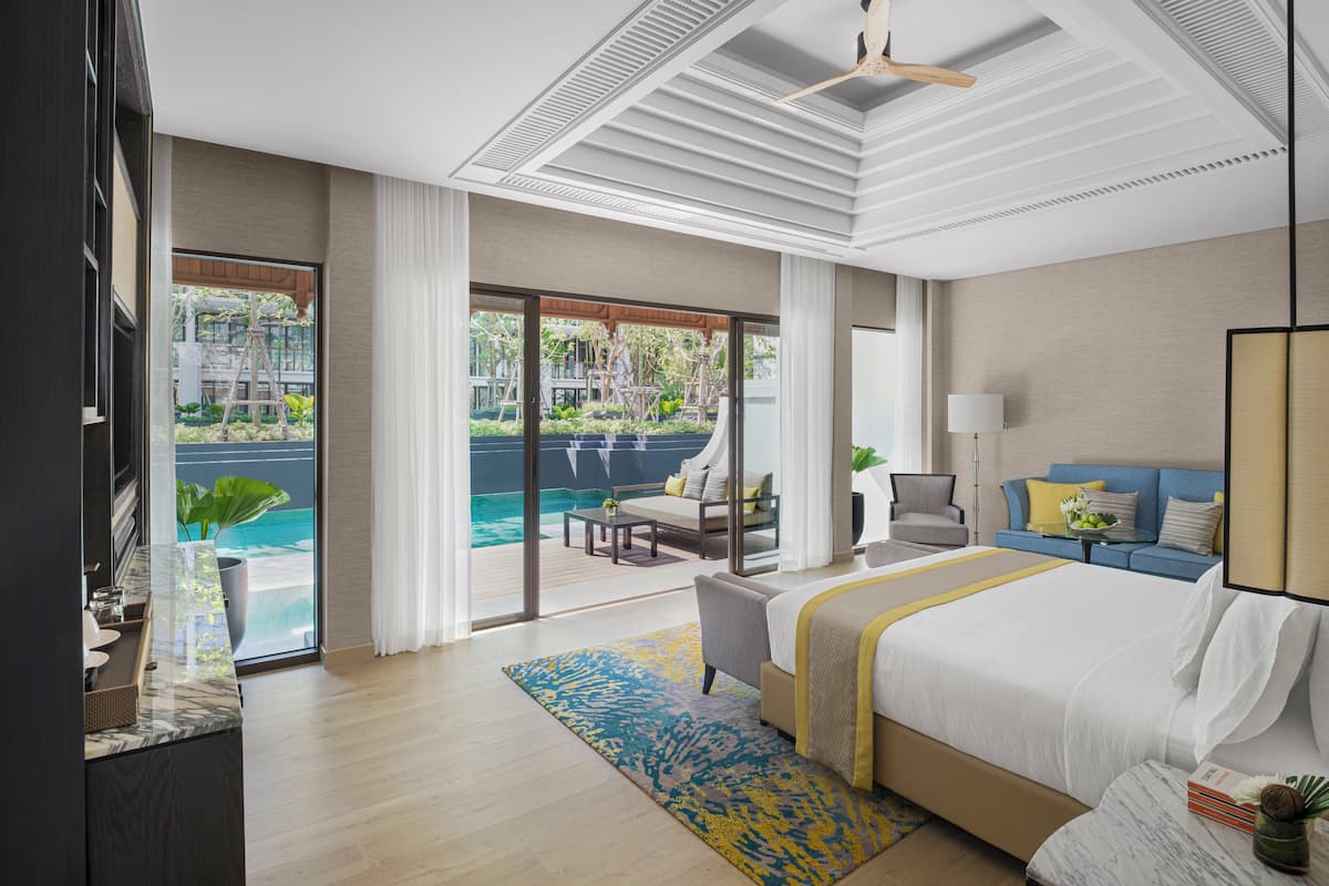 Een moderne hotelkamer met een groot bed, een balkon met zwembad en uitzicht op de omgeving.