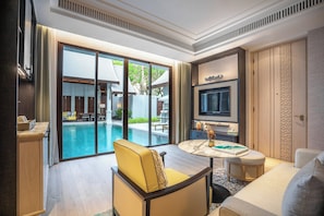 A modern living room with a pool view, a flat-screen TV, and a cozy seating area.
