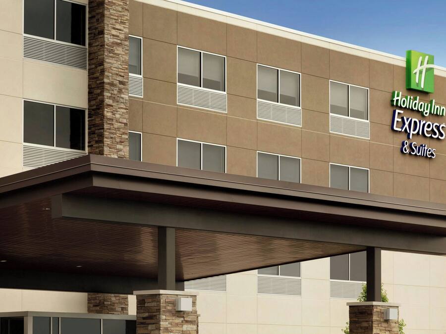 Un hotel Holiday Inn Express & Suites de diseño moderno, con techo plano, amplias ventanas y una entrada destacada con una marquesina.
