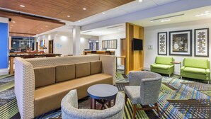 A hotel lobby with a sofa, chairs, a small table, and artwork on the walls. - Holiday Inn Express & Suites La Grange by IHG (La Grange)
