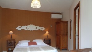 Ein Schlafzimmer mit einem Bett, zwei Nachttischen mit Lampen, einem Holzschrank und einer Deckenleuchte.