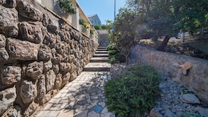 A stone pathway leading up a hill with a view of a building in the distance. - Wonderful private villa for 10 people with A/C, private pool, WIFI, TV and terrace (Novi Vinodolski)