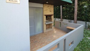 A villa named "Villa Marlene" with a brick fireplace and a covered patio area. - Villa just a few steps from the beach (Lignano Sabbiadoro)