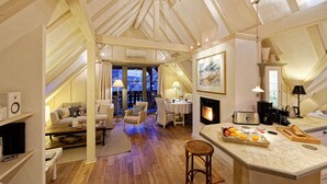 A cozy loft-style room with a dining area, a fireplace, and a view of the cityscape through large windows. - The WHITE STORK***** - loft & panoramic views (Riquewihr)