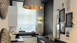 A modern kitchen with a central island, pendant lighting, and various framed quotes on the wall. - Best deal in town !  Cocoma Designer Apt deluxe in the center of Munich (Ludwigsvorstadt-Isarvorstadt)