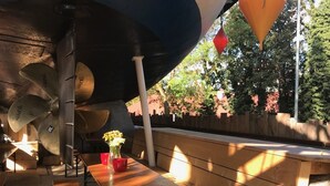 A wooden bench with a table underneath, surrounded by a metal structure with large, circular elements. - Best deal in town !  Cocoma Designer Apt deluxe in the center of Munich (Ludwigsvorstadt-Isarvorstadt)