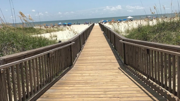 Ampla passarela plana que leva à praia.