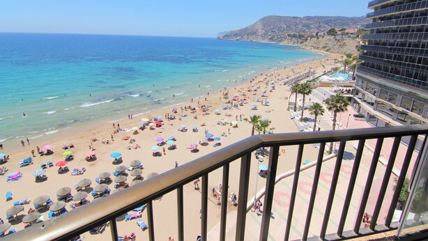 A beach with numerous umbrellas and people. - ACARI0406-1ºlínea Playa-Wifi y Garaje Gratis. (Calpe)