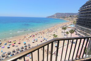 A beach with numerous umbrellas and people. - ACARI0406-1ºlínea Playa-Wifi y Garaje Gratis. (Calpe)