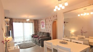 A modern living room with a dining area, a sofa, and a large mirror. - ACARI0406-1ºlínea Playa-Wifi y Garaje Gratis. (Calpe)
